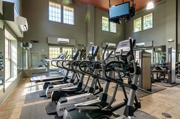 A gym with treadmills and elliptical machines.